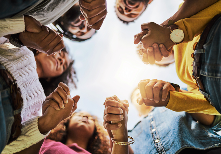 different races of hands on a bible